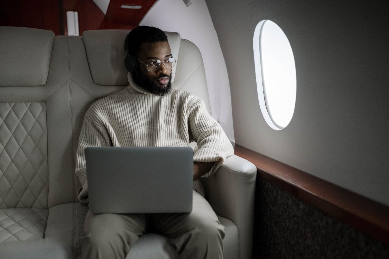 homme dans un avion qui regarde par le hublot